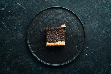 Poppy seed cake with chocolate and nuts. Dessert. On a black background. Top view.