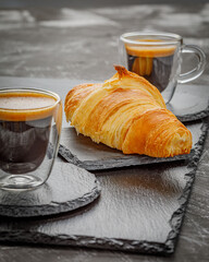 breakfast with coffee and croissant on the stone board