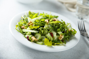 Healthy arugula salad with celery and walnut