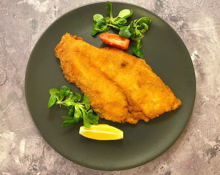 Classic breaded plaice fish fillets, coated in flour, egg, breadcrumbs and fried in oil to golden. Served with lemon.