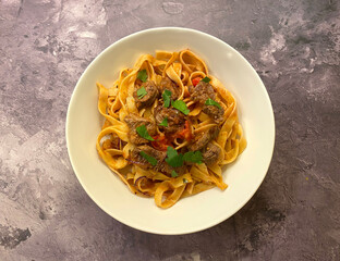 Beef strips, tagliatelle pasta and tomato sauce.