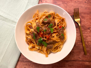 Beef strips, tagliatelle pasta and tomato sauce.