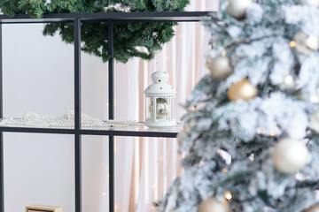 Winter decoration candlestick on the shelf near the fir tree. Christmas and New Year holidays mood.