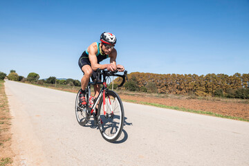 Fototapeta premium Cyclist with helmet and sunglasses riding in a rural path
