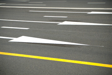 Fototapeta premium Direction arrows and lines on an asphalt road.