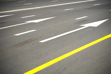 Direction arrows and lines on an asphalt road.