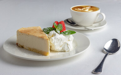 Slice of cake on white table.
Dessert and coffee