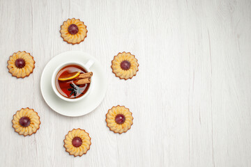 top view yummy grape cookies with cup of tea on the white background sweet dessert biscuit pie