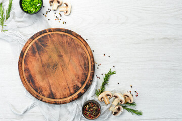 Food background. Kitchen board on the table with spices and herbs. Top view.