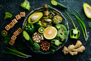 Fototapeta na wymiar Green foods: avocado, broccoli, parsley, celery, cucumber and kiwi. The inscription 