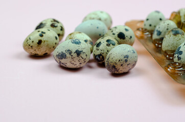 Quail eggs in a package on a pink background