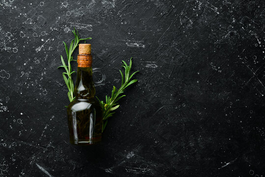 Jar of olive oil with spices on a dark background. Top view. Free space for your text.