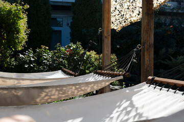 Relaxing outdoor garden scene with white hammocks surrounded by greenery in a green summer garden