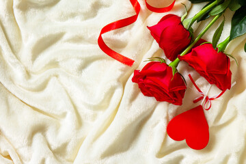 Valentines day surprise. Red roses and hearts on bed. Top view flat lay. Copy space.