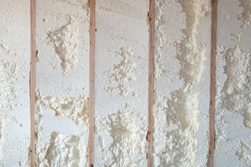Freshly applied foam insulation in a basement wall