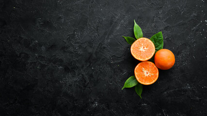Mandarin on a black stone background. Citrus fruits. Top view. Free space for your text.