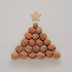 Christmas tree made of walnuts. Creative DIY decoration concept. Christmas and New Year square banner