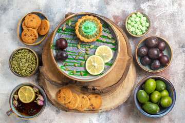 top view little cake with fruits and tea on light background photo biscuit candy sweet