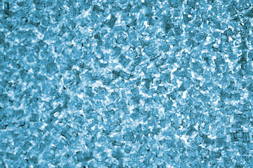 Obraz premium Ice and frost crystals on the window pane. Light blue tinted wallpaper. Unusual festive background for winter, Christmas or New Year. A backdrop that looks like broken glass