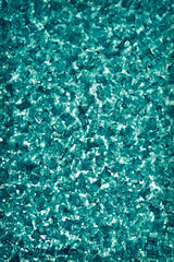 Dark blue green winter background. Abstract vertical wallpaper. Ice crystals on the window pane close up. Turquoise or cyan tinted backdrop with vignetting frame. Macro