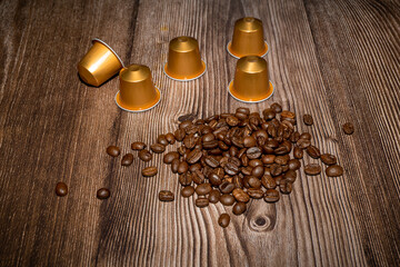 Espresso coffee capsules or coffee pods on wood background with roasted coffee beans