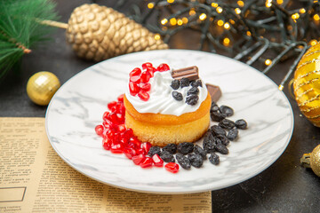 front view creamy cake with raisins and fruits around new year tree toys on a dark background cake sweet photo cream dessert