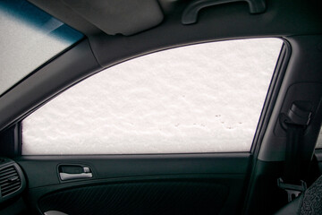 Car passenger side window in snow - view from the passenger compartment