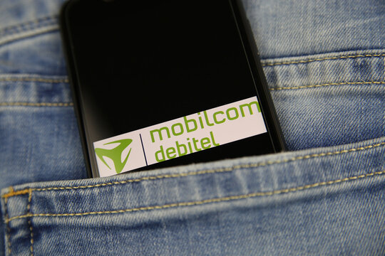 Viersen, Germany - May 9. 2020: Close up of smartphone screen in blue jeans pocket with logo lettering of german mobile phone provider mobilcom debitel (selective focus on center of lettering )
