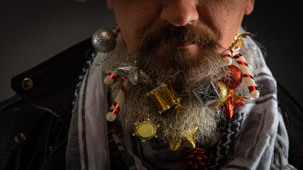 young handsome bearded man Santa Claus with a long beard in which toys in a black smoker and a...