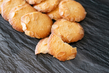 cookies with almond flakes on dark background.