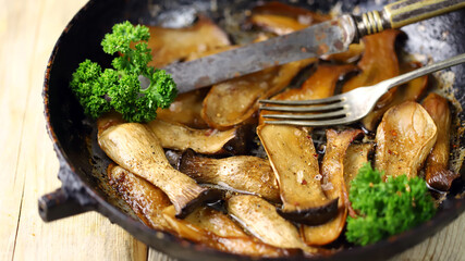 Fried eringi mushrooms in a pan. Appetizing mushrooms. Vegan lunch.