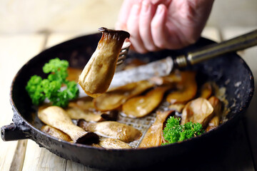 Fried eringi mushrooms in a pan. Appetizing mushrooms. Vegan lunch.