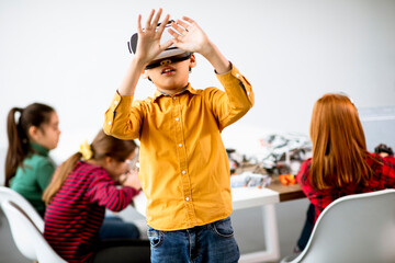 Cute little boy wearing VR virtual reality glasses