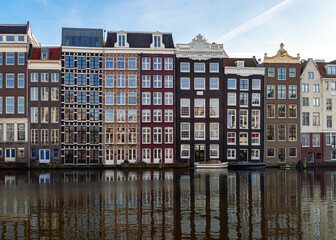 Amsterdam, The Netherlands 16 December, 2020: Old Amsterdam warehouses on the canal Damrak on a sunny winters day