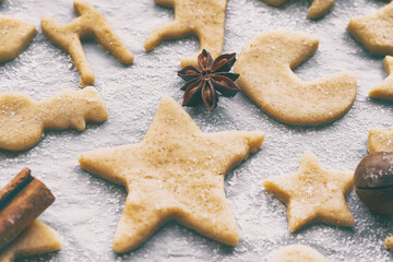 making homemade christmas or new year cookies of different shapes on parchment craft paper