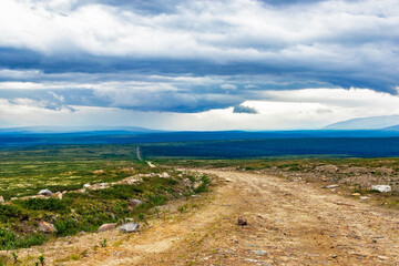 dirt road through the northern tundra to the mountains