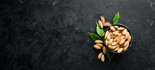 Walnut almonds in the shell. Nuts on a black stone background. Top view. Free space for your text.