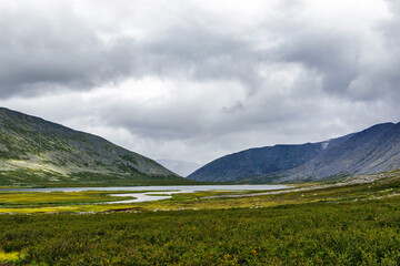 cold lake and mountain range on a rainy day