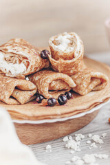 pancakes with curd filling and black currants on a plate