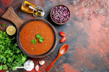 Above view of tomato soup on a brown cutting board on a mixed color background stock image
