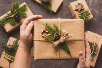 Female hands hold gifts in craft paper