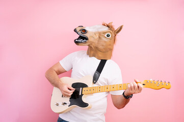 Man with horse mask playing electric guitar