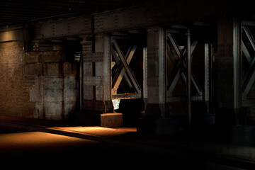 Fototapeta na wymiar Area of light in the dark place under a metal bridge
