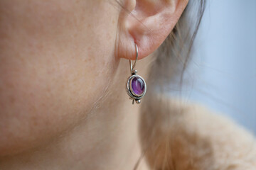 Female ear wearing sterling silver amethyst mineral stone earring