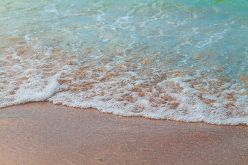 Turquoise wave of the sea on the golden sand of the beach.