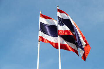 Image of waving flag of Thailand with blue sky background.