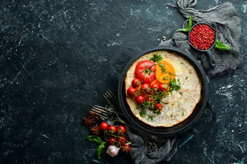 Omelet with tomatoes and parsley in a pan. Food for breakfast. Free space for your text. Top view.