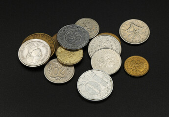 coins of different countries on a black background