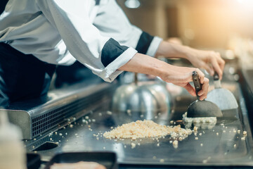 Hand of man take cooking of meat with vegetable grill, Chef cooking wagyu beef in Japanese teppanyaki restaurant