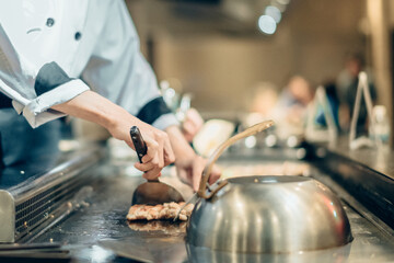 Hand of man take cooking of meat with vegetable grill, Chef cooking wagyu beef in Japanese teppanyaki restaurant